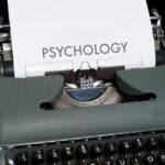 Close-up of an antique typewriter printing the word 'psychology', symbolizing retro communication.