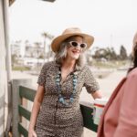 Two stylish women chatting outdoors, showcasing summer fashion and joy.